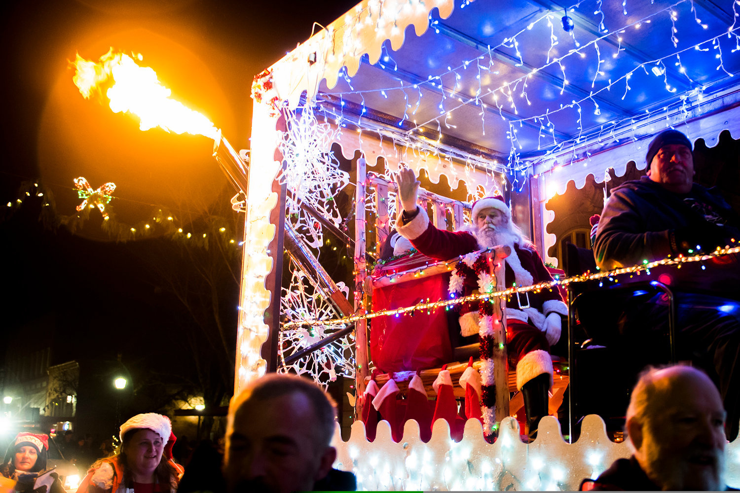 FILE PHOTO — Santa waves to crowds as flames shoot from the back of a semi during the annual Lighted Tractor Parade.